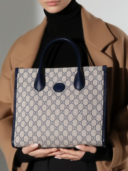 Person holding a Gucci Small Tote Bag With Interlocking G Navy 659983 K9GSN 4075 with blue accents