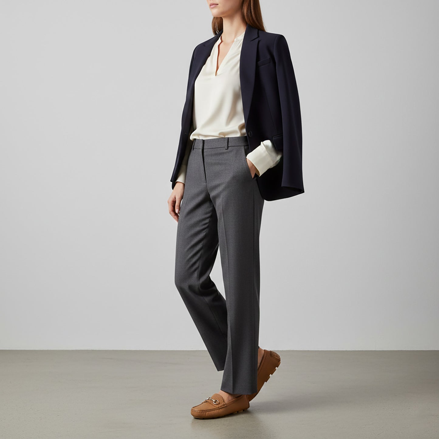 Person wearing a navy blazer, white shirt, gray pants, and Gucci Women’s Horsebit Driver Loafers Brown 815464 AAC4Q 2712 on a plain background