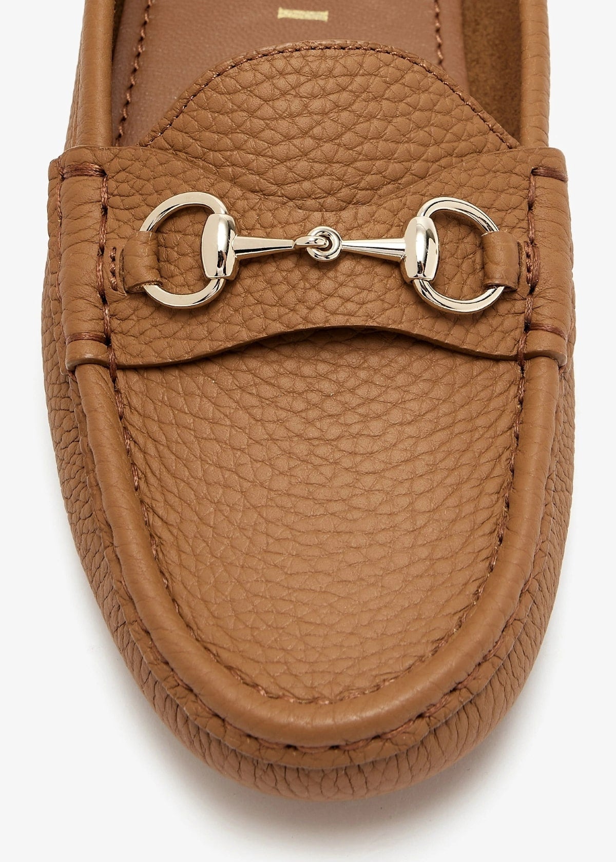 Brown leather loafer with a metallic buckle on a white background