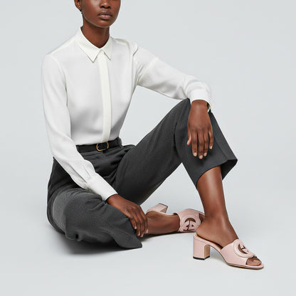 Person wearing a white shirt, gray pants, and Gucci Women’s Slide Sandal Interlocking G Pink 782413 AAAZG 5908 on a light gray background