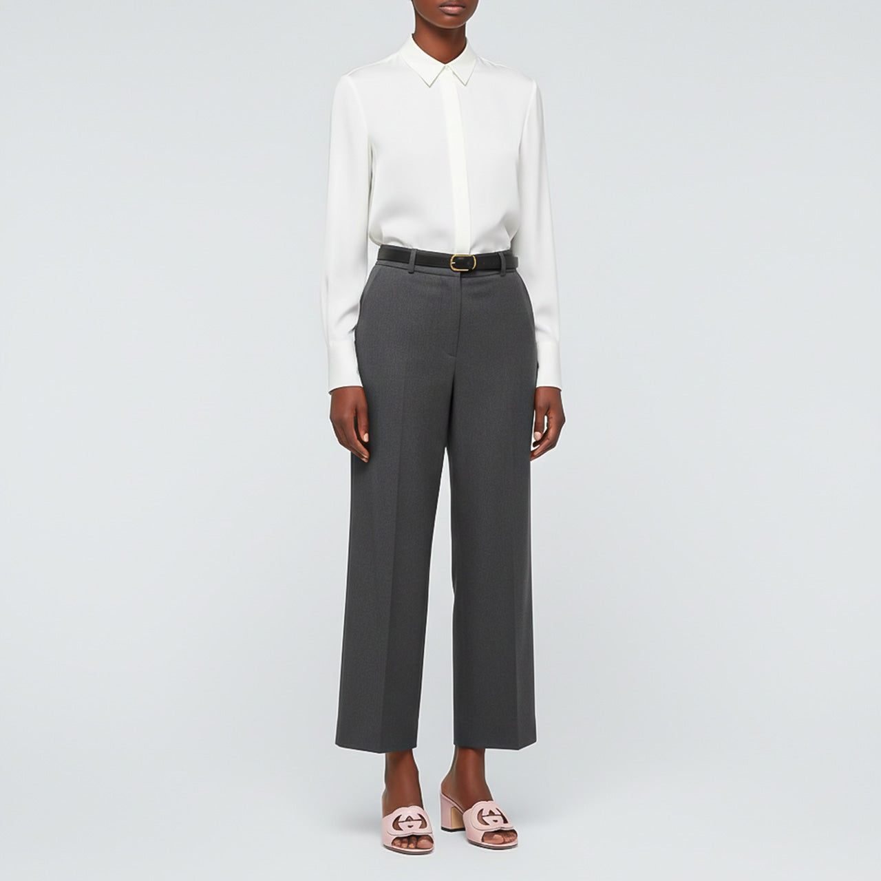 Person wearing a white shirt and gray pants with Gucci Women’s Slide Sandal Interlocking G Pink 782413 AAAZG 5908 on a light gray background