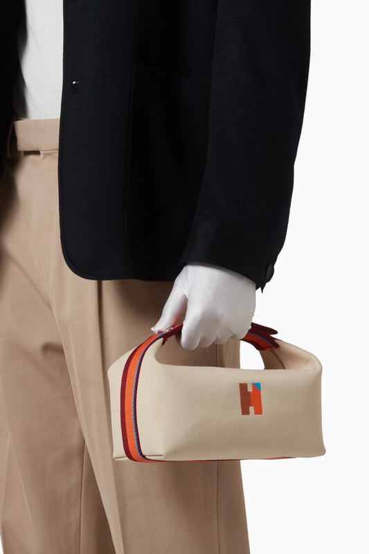 model holding a Hermès Small Bride-a-Brac H Pavillon Case Natural H104346Mv01