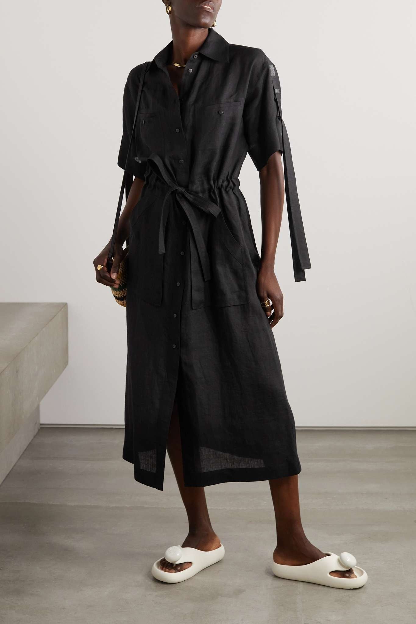 Model wearing a black dress with a Loewe Paula Ibiza Foam Thong Slide White L616S03X02 2100 in a minimalistic setting