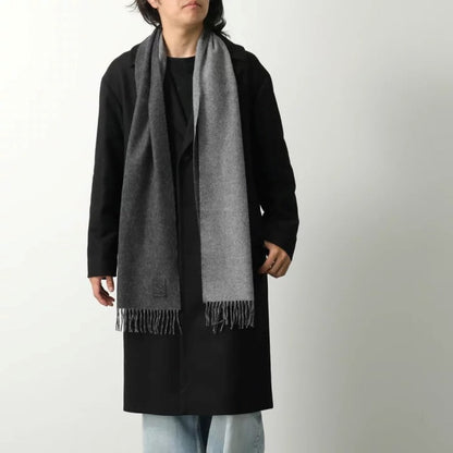 Person wearing a long black coat and Loewe Scarf in Wool and Cashmere Black/Grey F811251X06-1114 on a white background