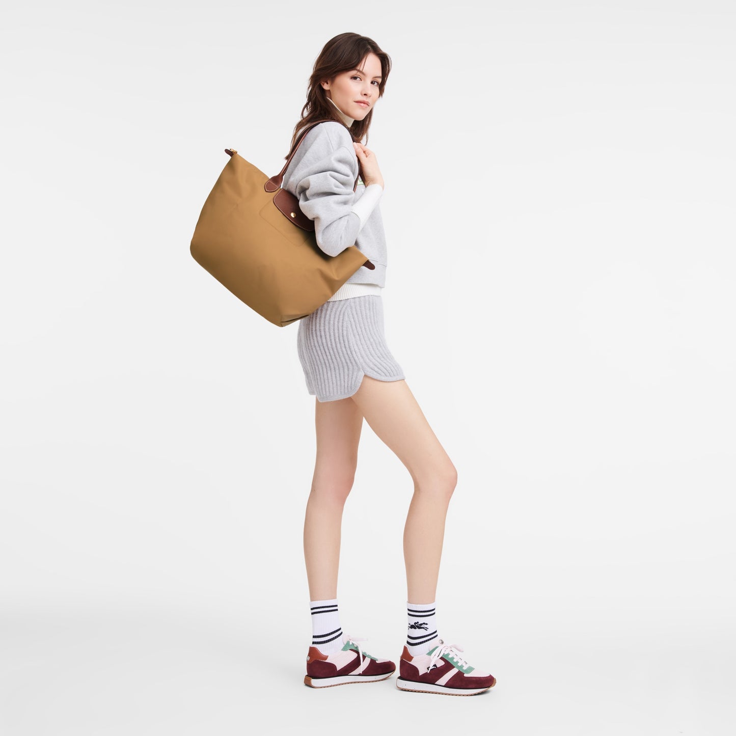 Woman holding a Longchamp Le Pliage Original L Tote Bag Fawn L1899089P86 on a white background