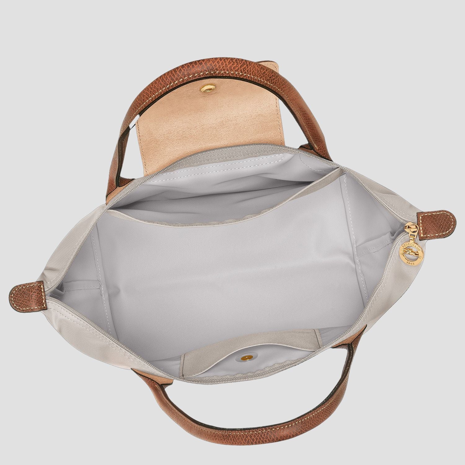 Open Longchamp Le Pliage Original M Tote Bag – Pebble L2605089349 with brown handles and trim on a light gray background