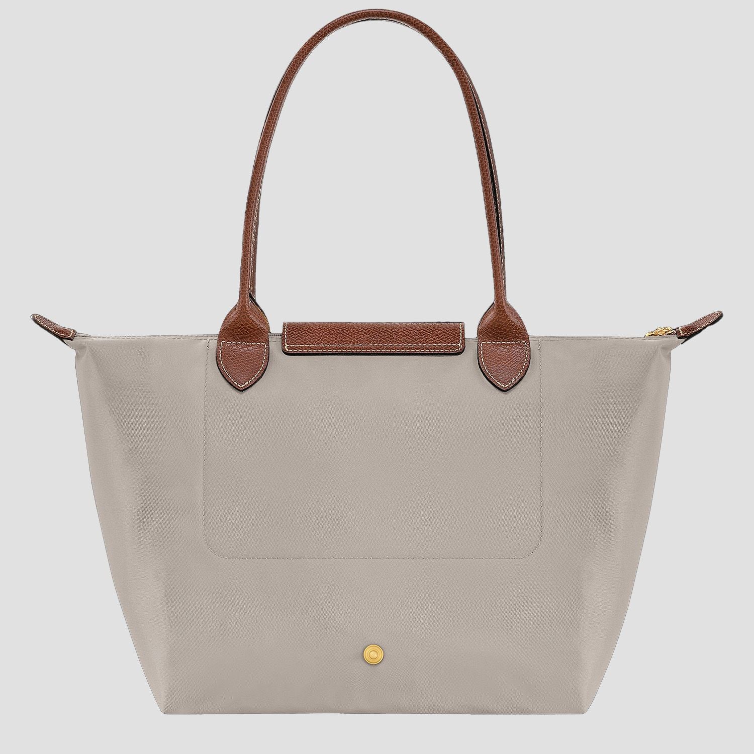behind Longchamp Le Pliage Original M Tote Bag – Pebble L2605089349 with brown handles on a light gray background