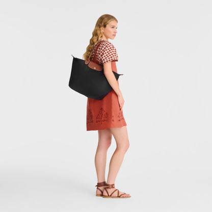Woman holding a Longchamp Le Pliage Original Tote Bag L – Black L1899089001 on a white background