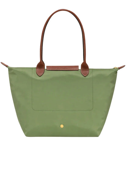 behind Longchamp Le Pliage Original Tote Bag L – Lichen L1899089P77 with brown handles on a white background