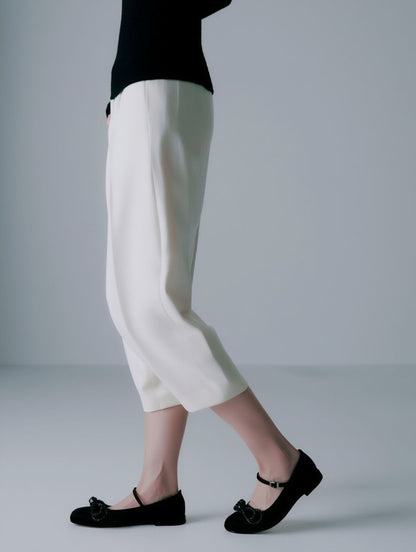 Person wearing white pants and MACH & MACH Double Bow Black Satin Ballerinas on a plain background