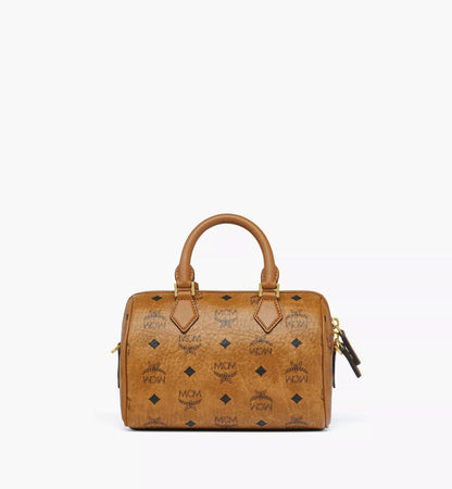 Behind MCM Small Ella Boston Bag in Visetos Cognac MWBFAEA03CO001 with gold accents on a white background