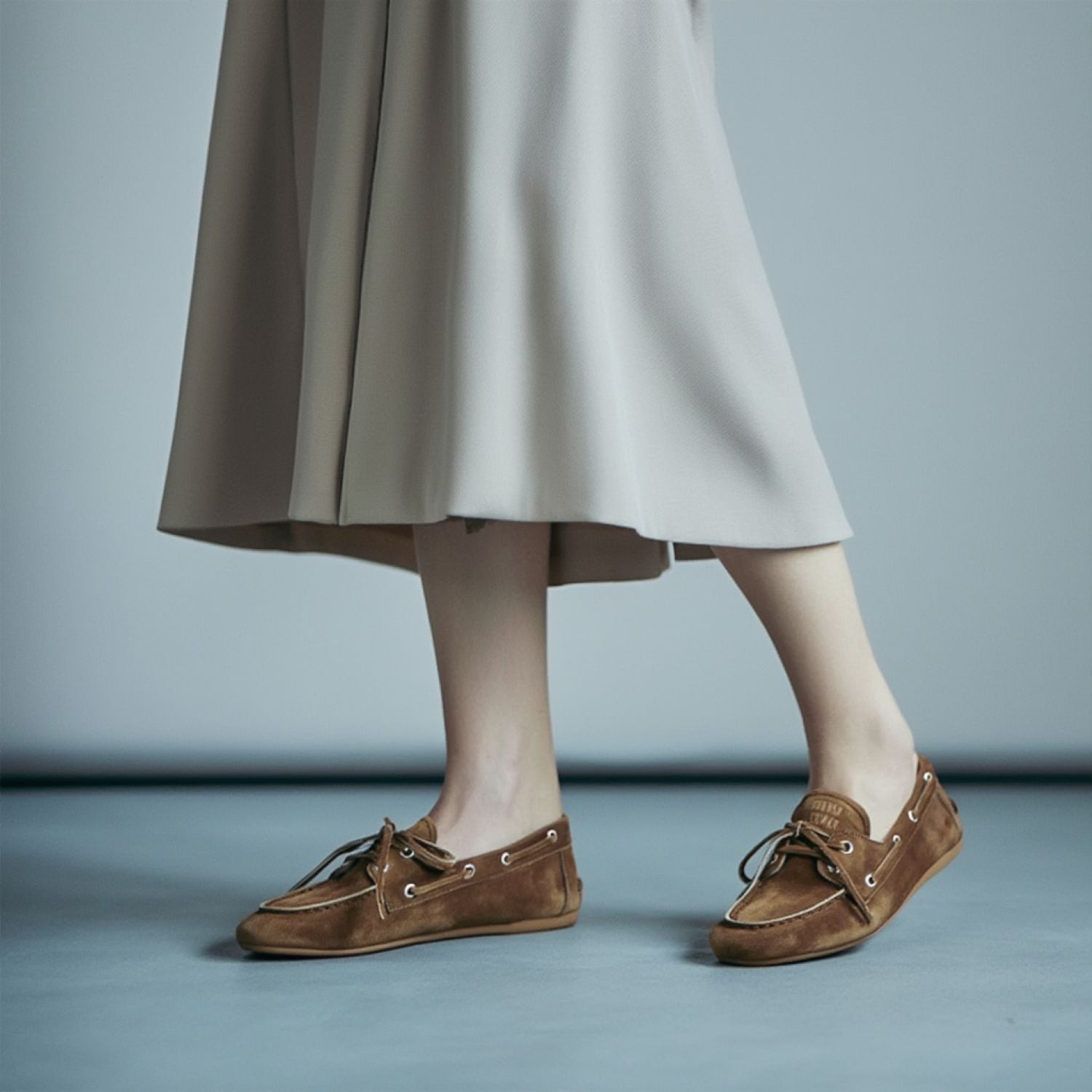 Miu Miu Faded Unlined Suede Loafers – Cinnamon 5D123E_Z5O_F0401_F_D005 worn with a beige skirt on a plain background