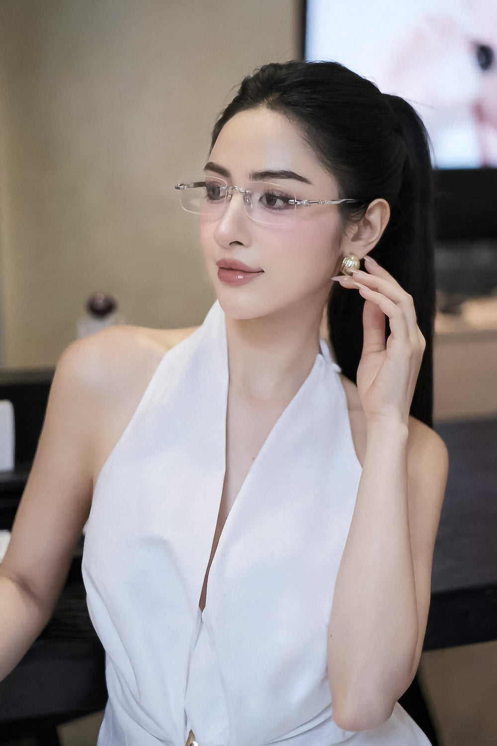 Woman wearing Miu Miu MU 50YV 1BC1O1 Rimless Silver Eyeglasses and a white dress in an indoor setting