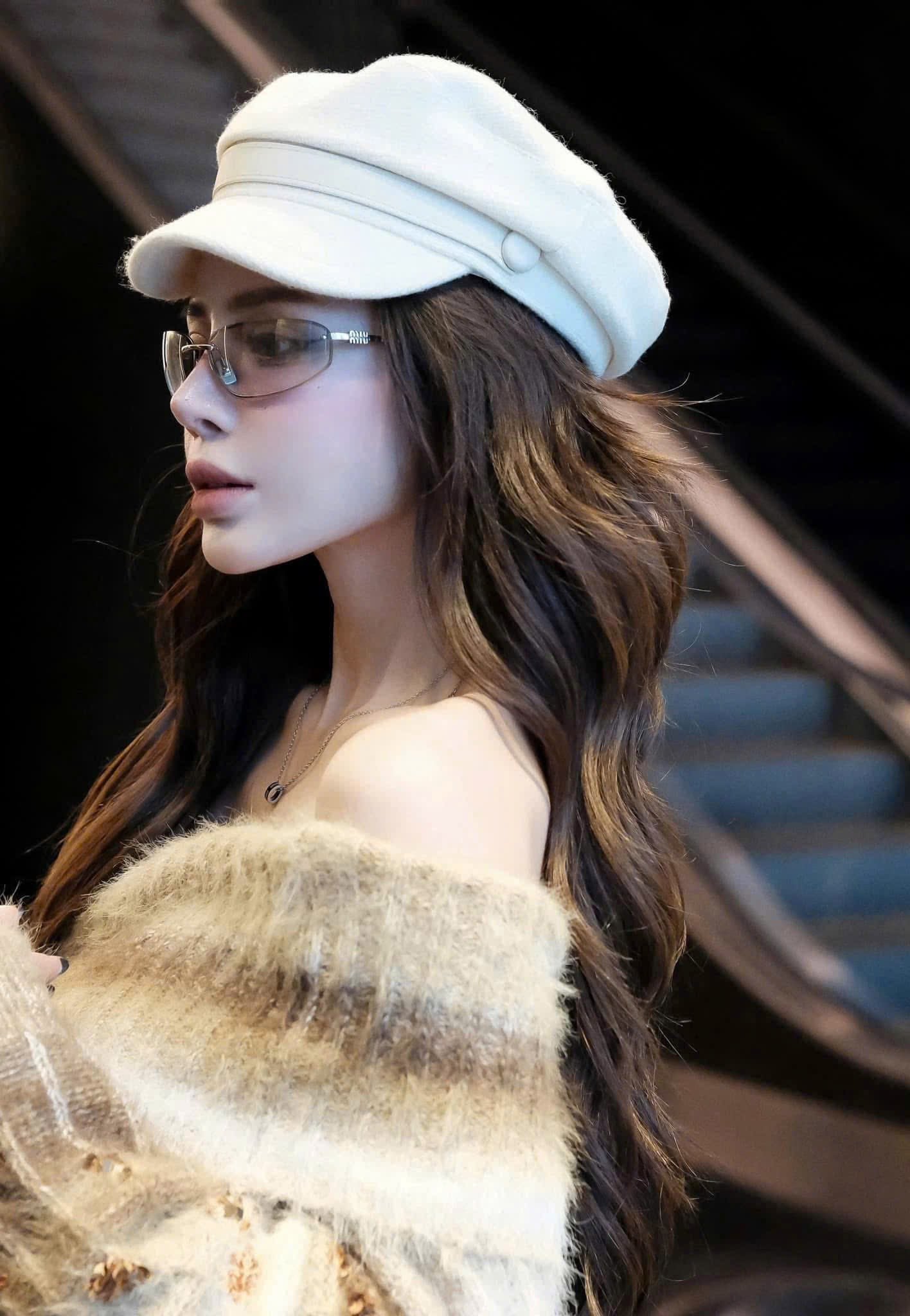 Woman wearing a white cap and Miu Miu MU A50S 1BC8H1 Sunglasses with a blurred background
