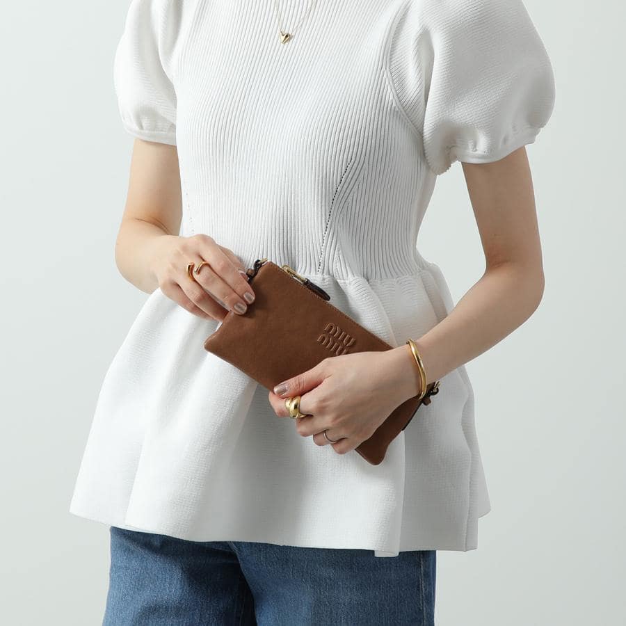 Person holding a Miu Miu Oak Nappa Leather Mini Pouch 5NI007_AEFX_F0316 with a plain background