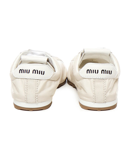 behind Miu Miu Plume Technical Fabric and Suede Sneakers – Ivory 5E114E_D7C_F0304_F_D005 with brown soles on a white background
