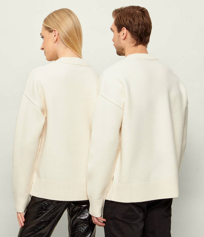 Behind two people wearing Ami Paris Natural Wool Crewneck Sweater With Contrasted Ami De Coeur Off/White UKS838.018.154 and black pants against a plain background
