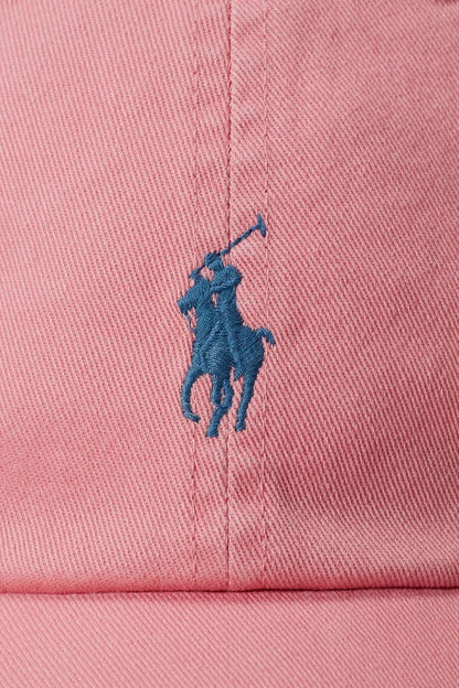 Pink cap with a blue embroidered logo on a pink background
