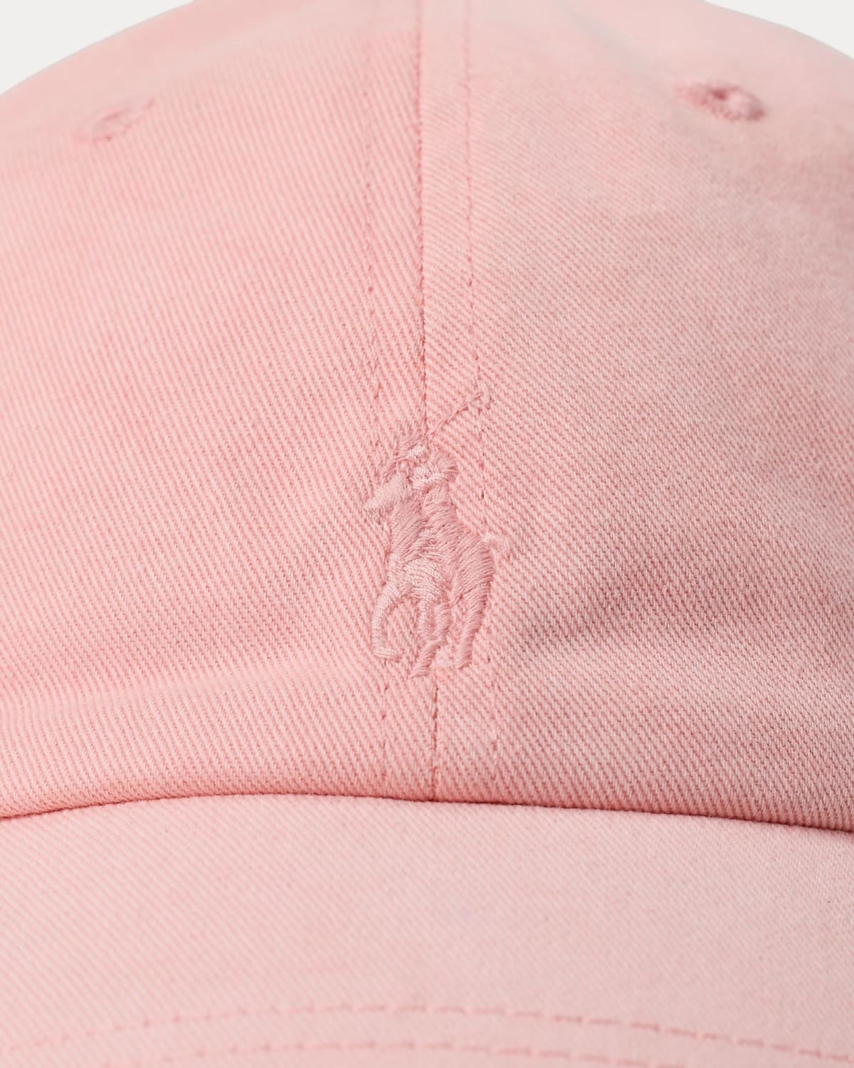 Close-up of a pink cap with a logo on a white background