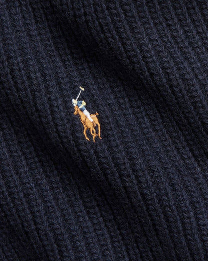 Close-up of a navy blue fabric with a embroidered logo featuring a polo player and horse.