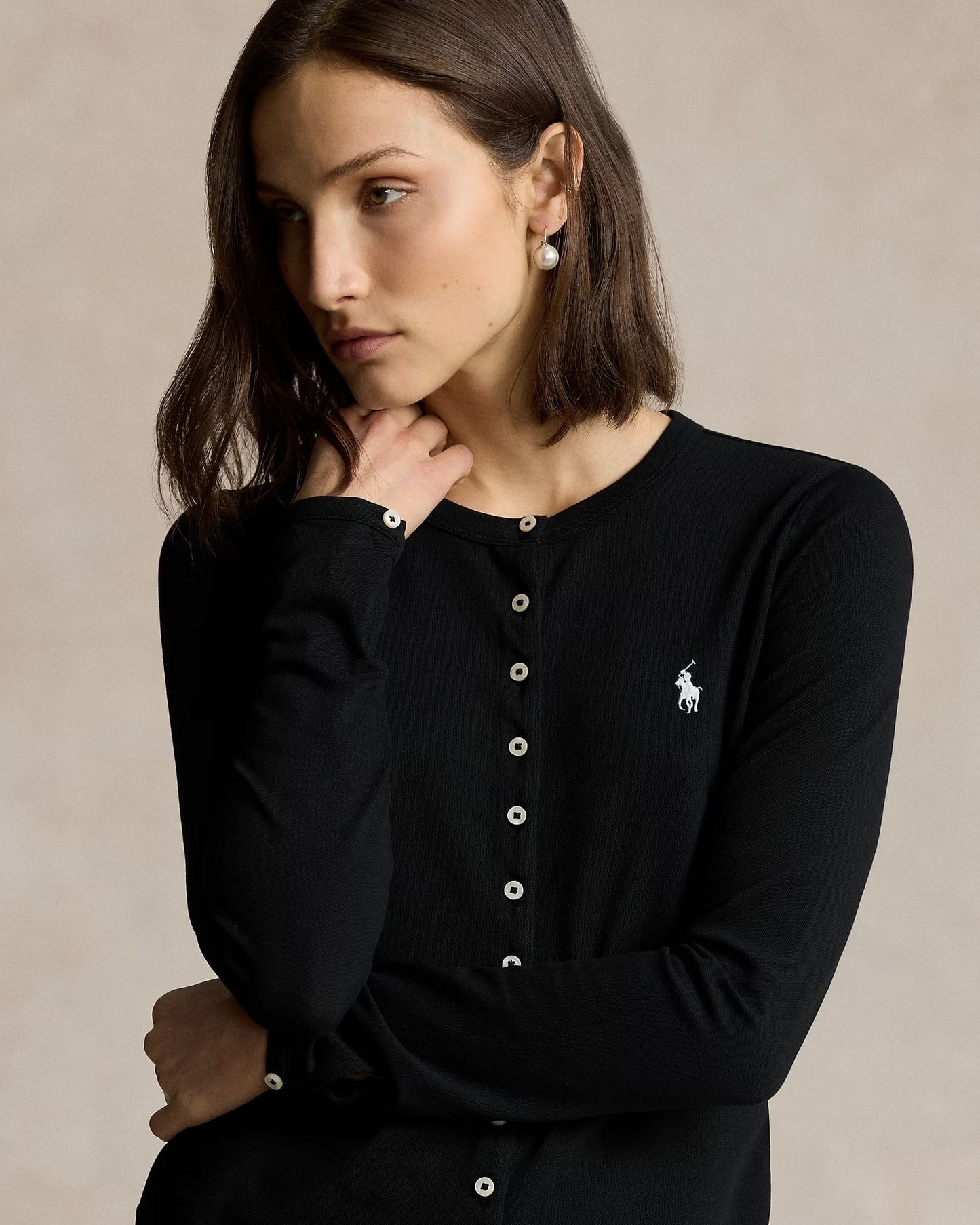Woman wearing a Polo Ralph Lauren Stretch Mesh Cotton Crewneck Cardigan – Black 211941175002 with a small logo on a beige background