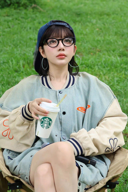 A girl wearing Prada PR A11VD 16K1O1 Oval Black Eyeglasses and sitting on a bench with a Starbucks cup in a grassy area