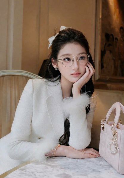 Woman wearing Prada PR A50V ZVN1O1 Round Gold Eyeglasses in a white outfit with a pink handbag in an indoor setting
