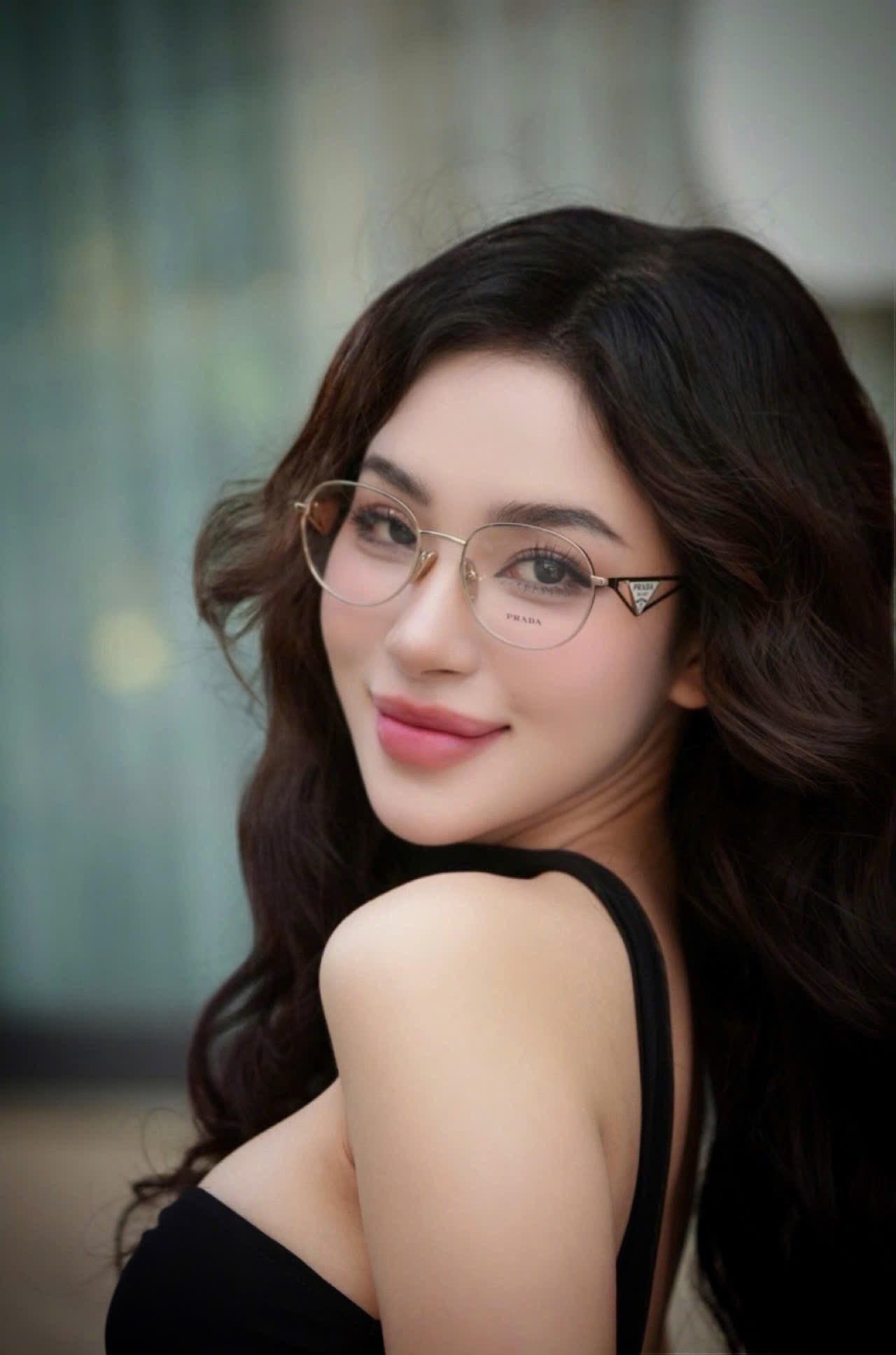 Woman wearing Prada PR A50V ZVN1O1 Round Gold Eyeglasses with a blurred background