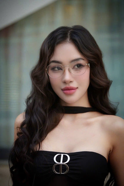 Woman wearing Prada PR A50V ZVN1O1 Round Gold Eyeglasses and a black dress with a brand logo.