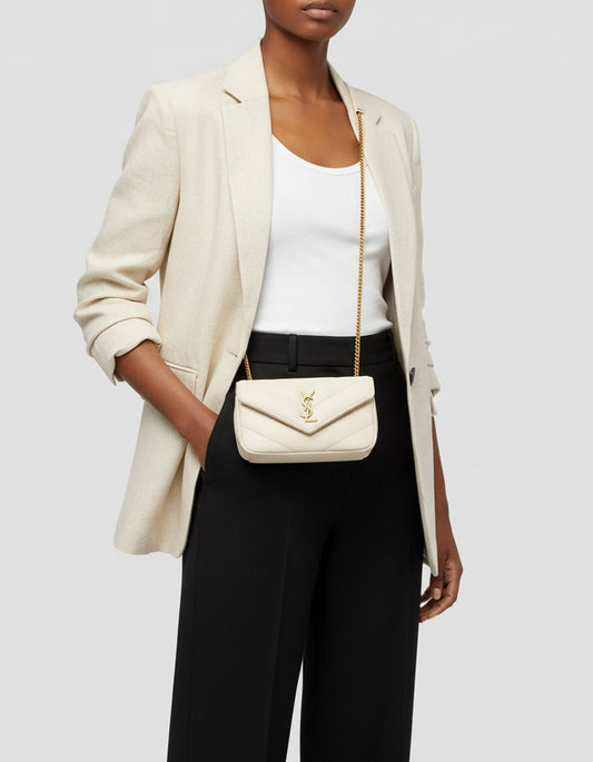 Person wearing a beige blazer, white top, and black pants with a Saint Laurent LOULOU MINI in Lambskin Blanc Vintage 821749AAEAX9207