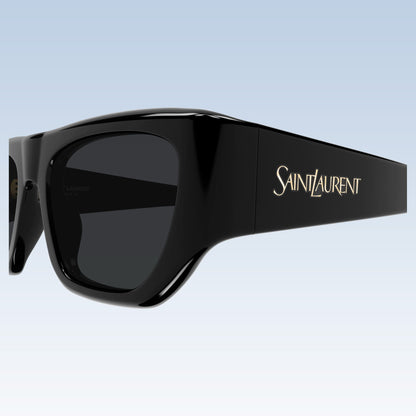 Saint Laurent SL 740 005 oversized square sunglasses with a glossy black frame, dark lenses, and gold logo lettering on the temple, shown against a light blue gradient background.