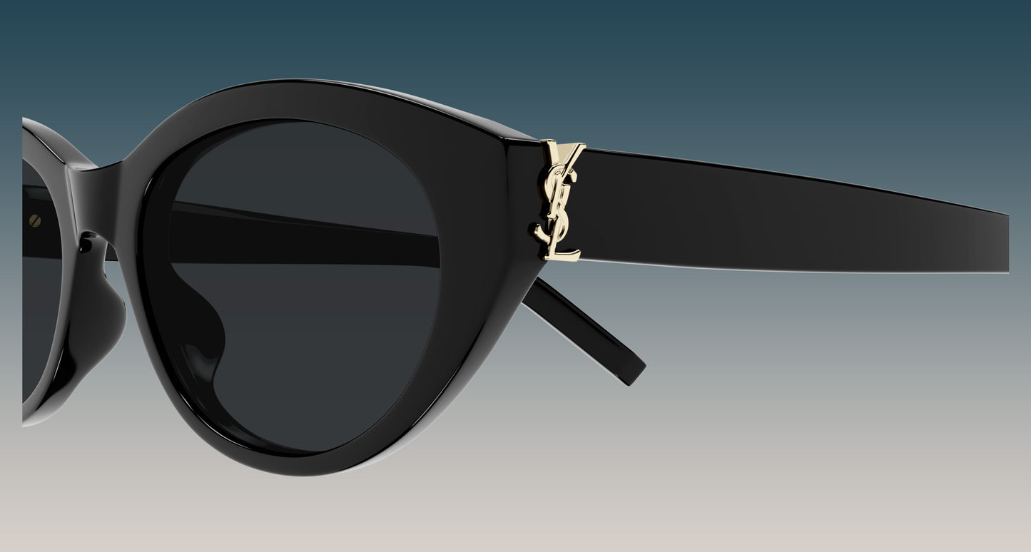 Saint Laurent SL M148 001 Black Round Sunglasses with dark lenses and a gold-tone YSL logo on the temple, shown against a gradient blue-to-gray background.