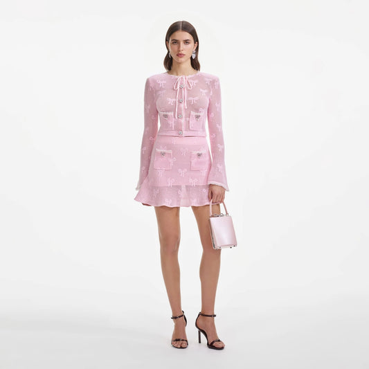 Woman wearing a pink outfit with a matching Self-Portrait Pink Leather Tote Bag SS25-325-P on a white background