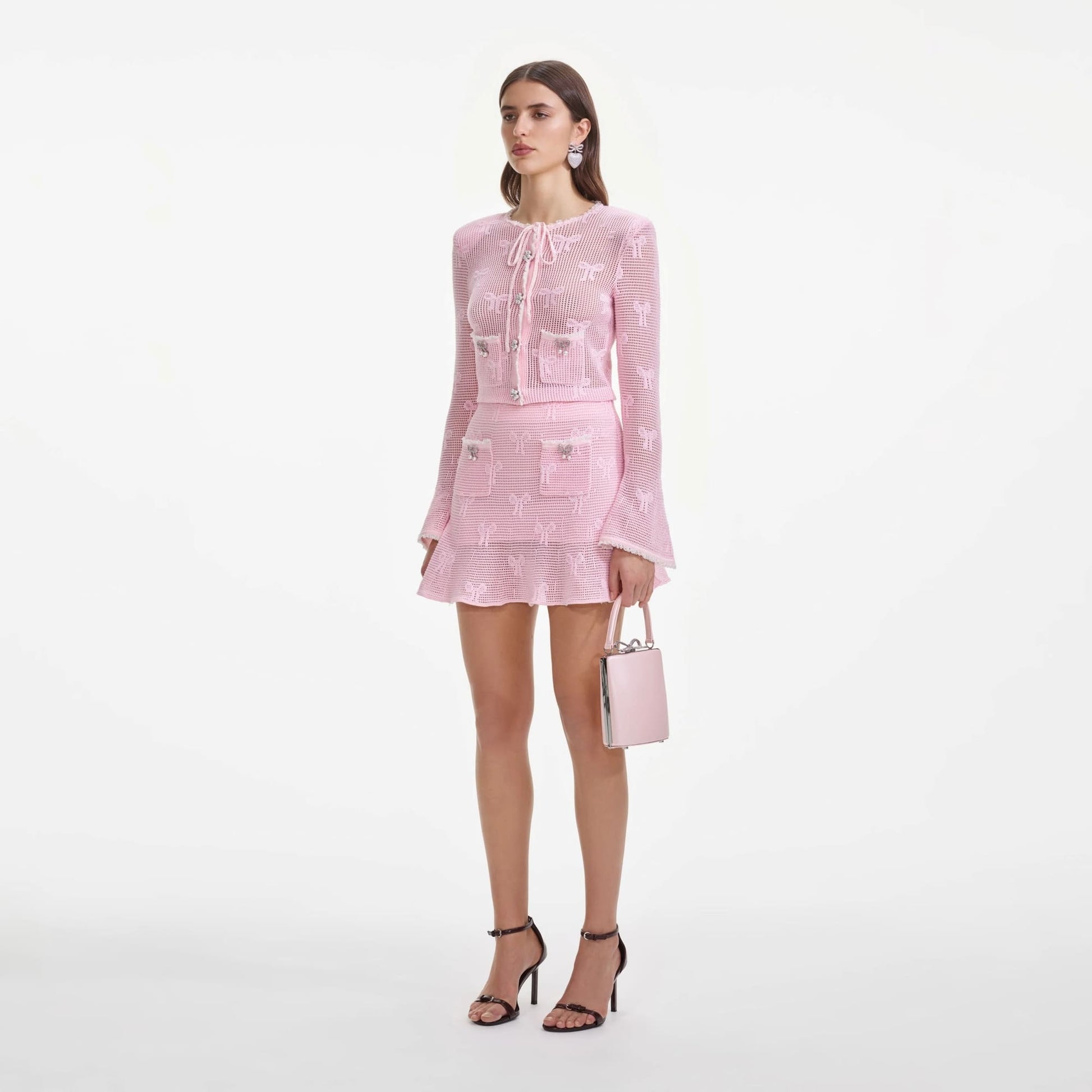 Woman wearing a pink outfit with a matching Self-Portrait Pink Leather Tote Bag SS25-325-P on a white background