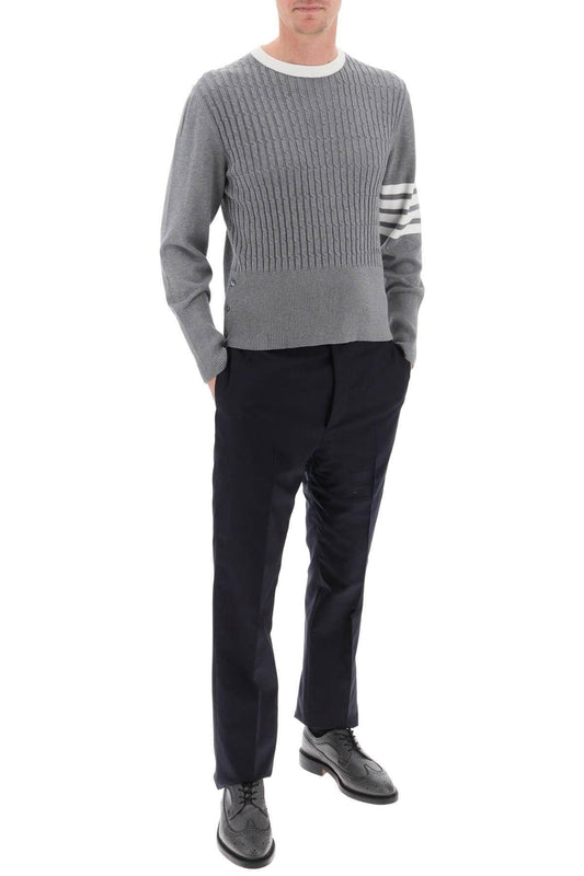 Person wearing a Thom Browne 4-Bar Placed Baby Cable Sweatshirt MKA497A Y3014 055 with white stripes and black pants on a white background
