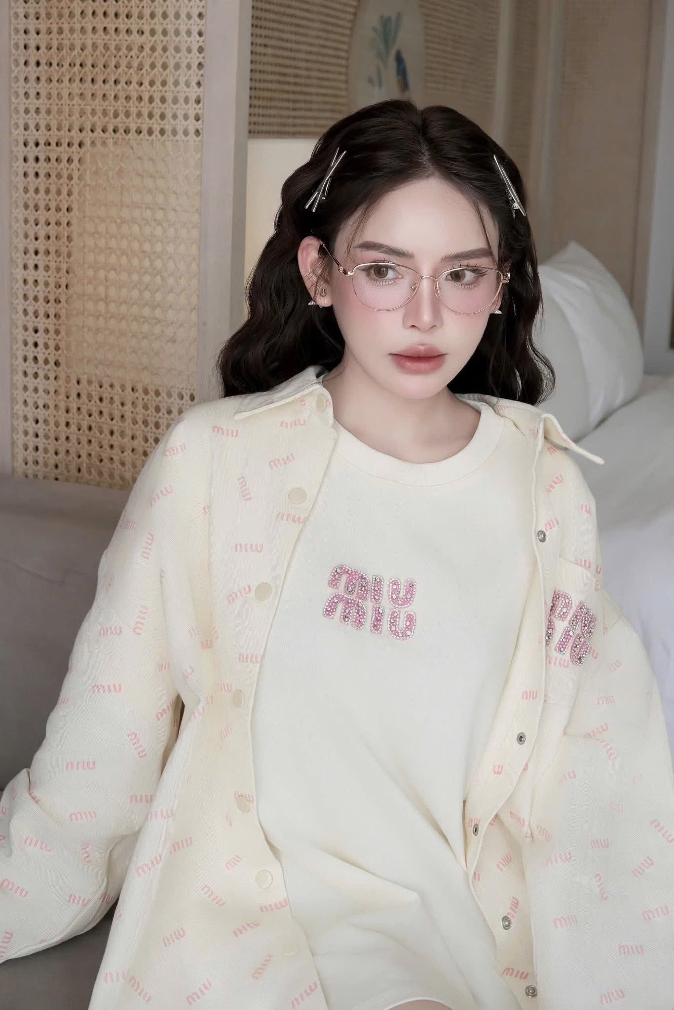 Woman wearing Tiffany &amp; Co TF1164B 6021 Gold Cat-Eye Eyeglasses in a light-colored outfit with 'Miu Miu' branding in a bedroom setting