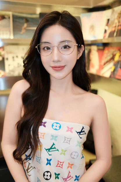 Woman wearing Tiffany &amp; Co TF1164B 6021 Gold Cat-Eye Eyeglasses in a colorful dress with a pattern in an indoor setting