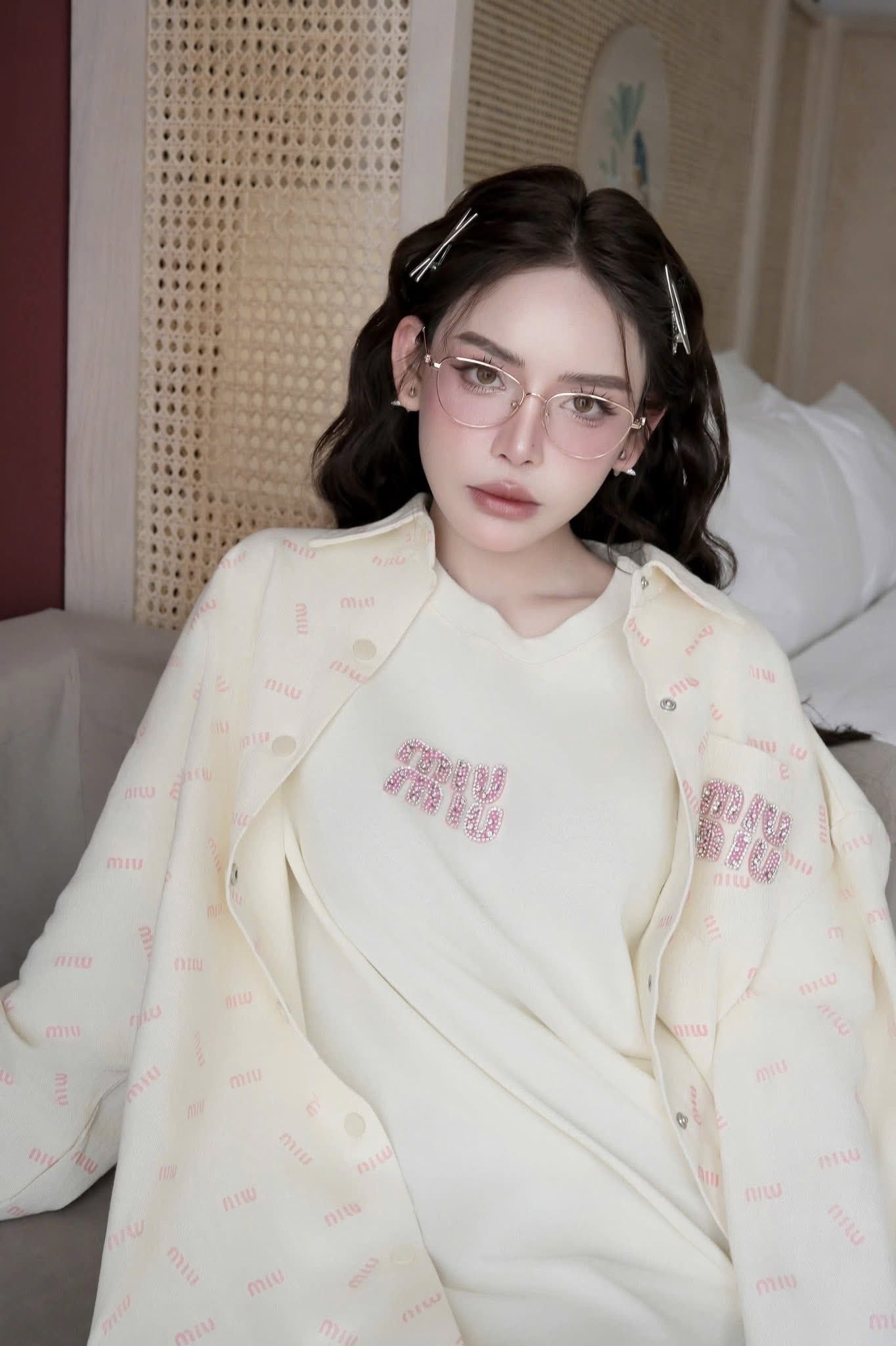 Person wearing Tiffany & Co TF1164B 6021 Gold Cat-Eye Eyeglasses in a light-colored outfit with text, sitting on a bed.