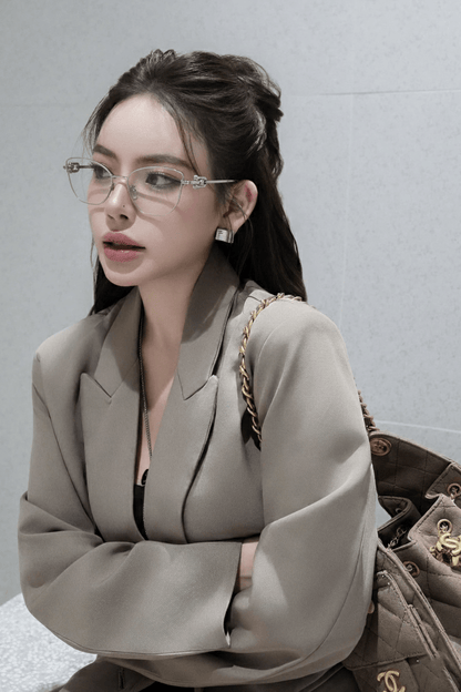 Woman wearing Tiffany TF1166 6001 Silver Eyeglasses and a beige suit with a handbag against a gray background