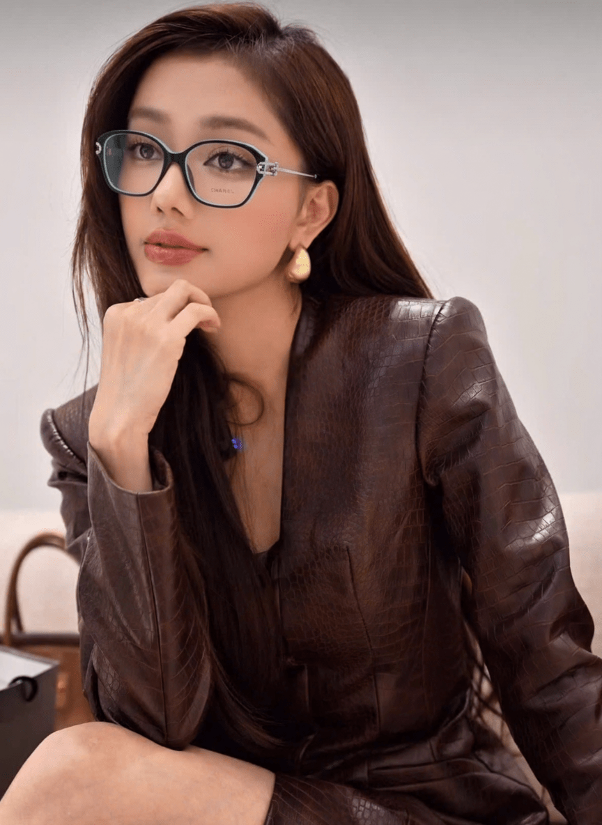 Woman wearing Tiffany TF2266 8055 Blue Black Silver Eyeglasses and a brown leather outfit sitting on a couch.