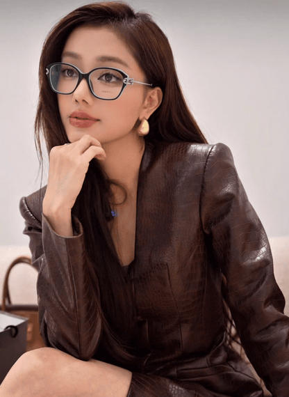 Woman wearing Tiffany TF2266 8055 Blue Black Silver Eyeglasses and a brown leather outfit sitting on a couch.