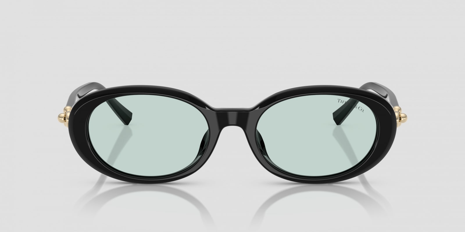 Black oval sunglasses with gold accents on a light gray background