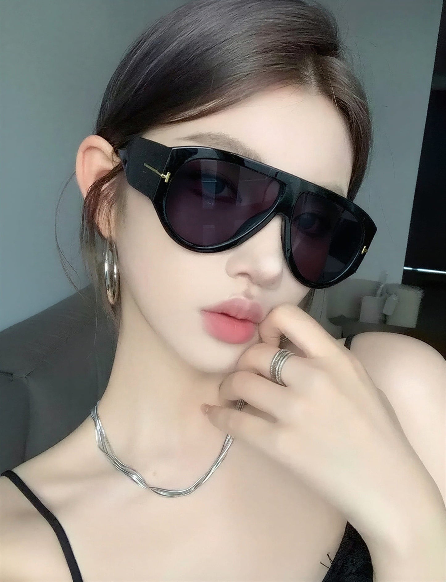 Wiomen wearing black Tom Ford Bronson FT1044 01A Sunglasses with a neutral background