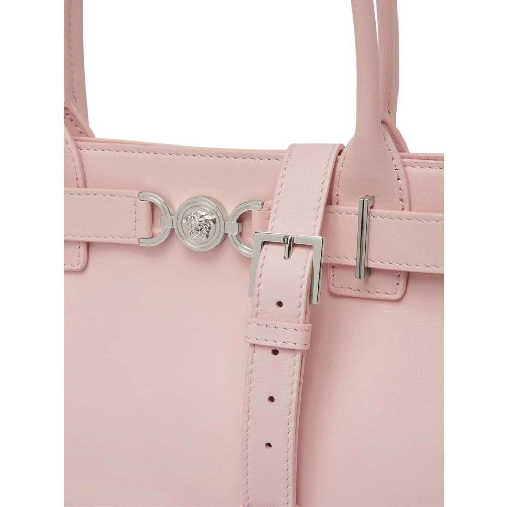 Close-up of a pink handbag with silver hardware on a white background
