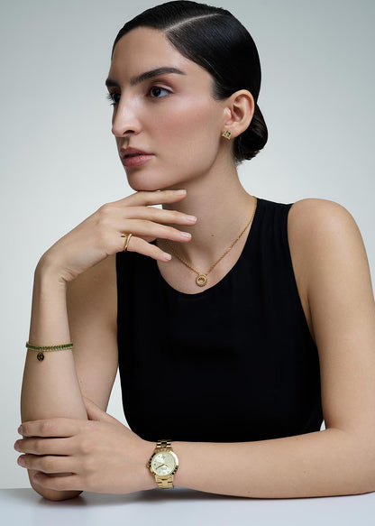 Woman wearing gold jewelry including a necklace, bracelet, and Vivienne Westwood Bloomsbury Gold Watch vv152gdgd on a plain background