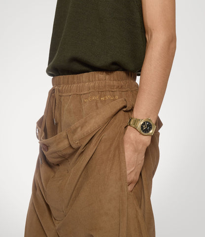 Person wearing a brown skirt and green top with Vivienne Westwood Hanwell Black Dial Gold Watch VV335BKGD 8050164231910 on a white background