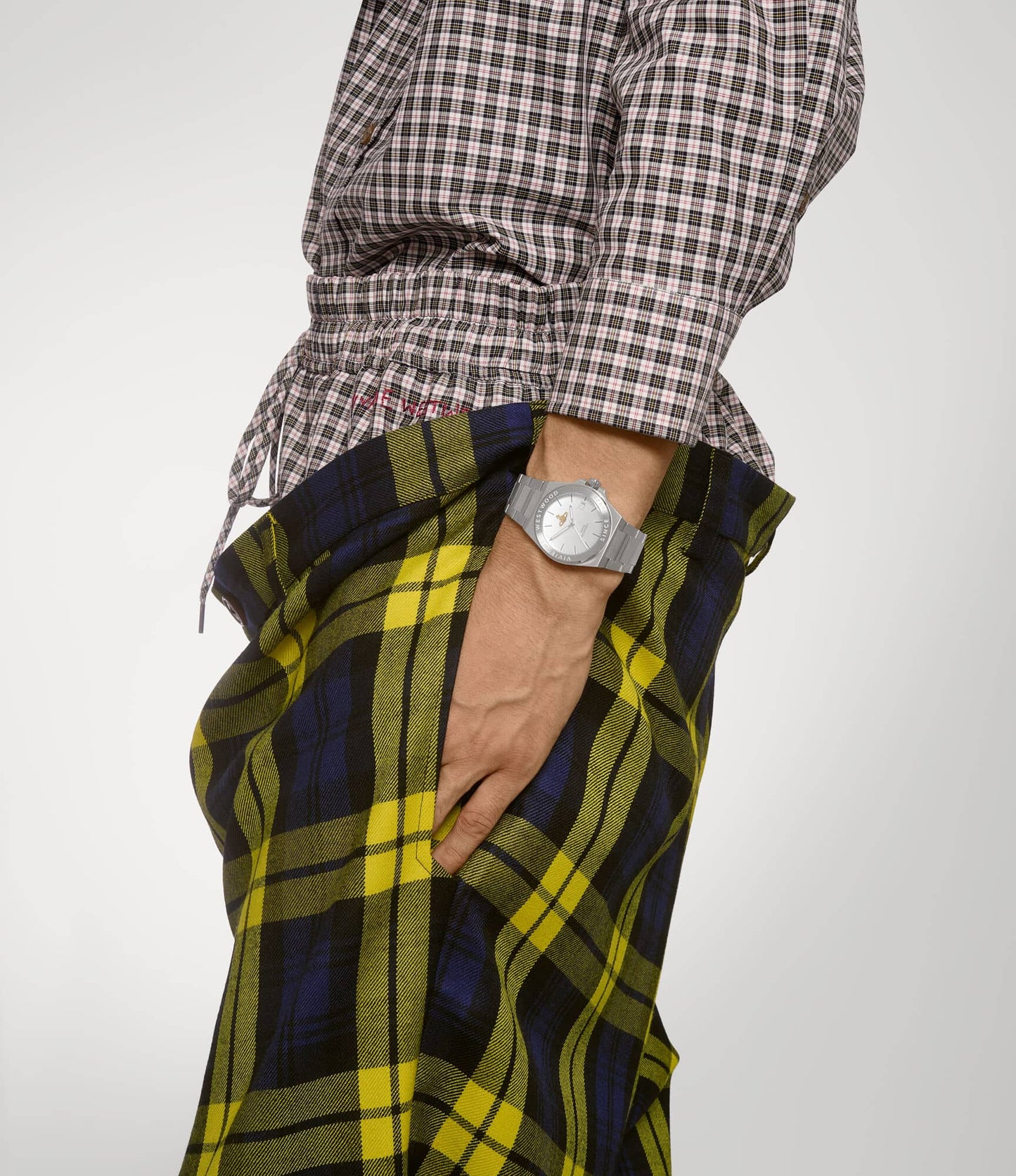 Person wearing a plaid shirt and colorful pants with a Vivienne Westwood Hanwell Silver Watch VV335SLSL 8050164231927 on a plain background