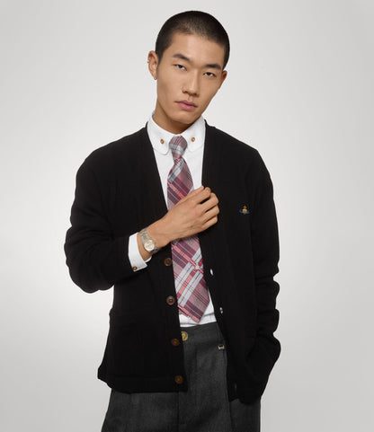 Man wearing a black cardigan over a white shirt with a Vivienne Westwood Hoxton Dual-Tone Silver Watch VV332SLSG 8050164231880 on a light gray background