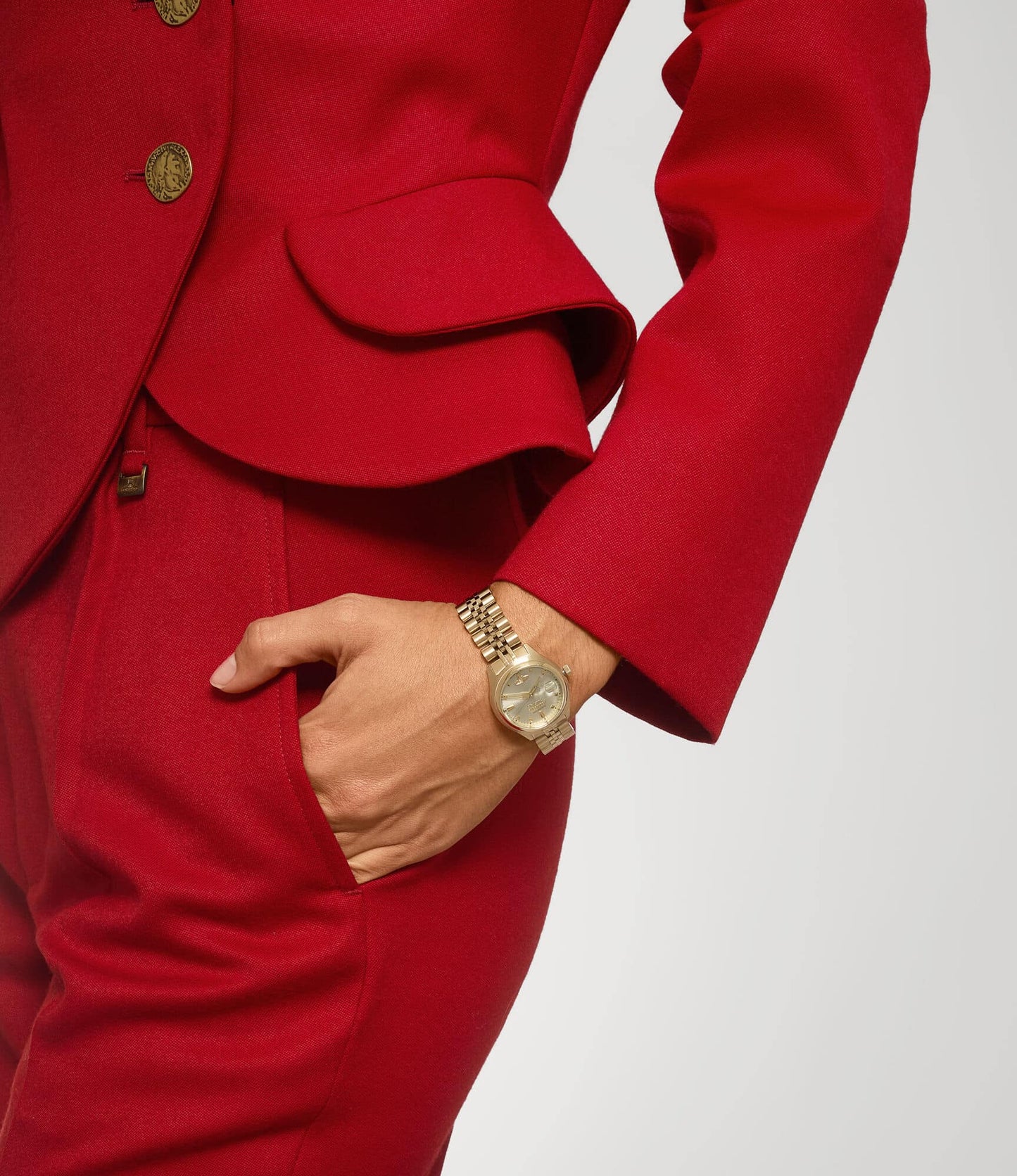 Red suit with gold buttons and a Vivienne Westwood Little Camberwell Gold Watch VV311CPGD 8050164231835 on a plain background