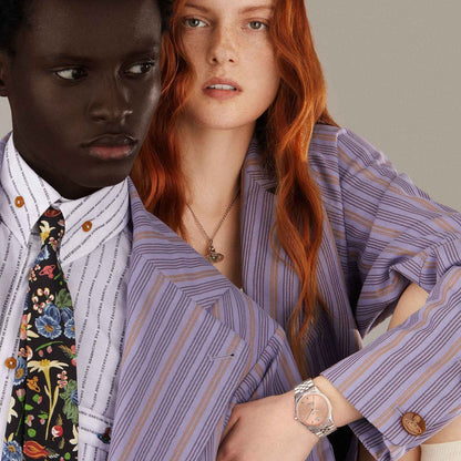 Two people wearing matching striped shirts with a neutral background